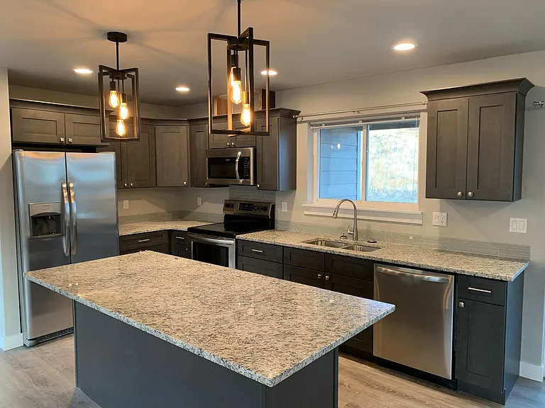 Kitchen with stainless steel and granite counter tops (lighting varies in unit)