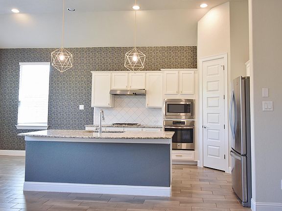 The kitchen includes stainless steel appliances, including a gas range.