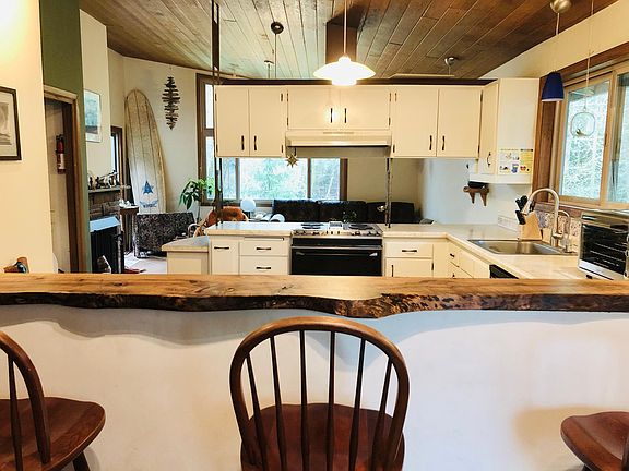 Dining bar with view into kitchen, dining room and backyard.