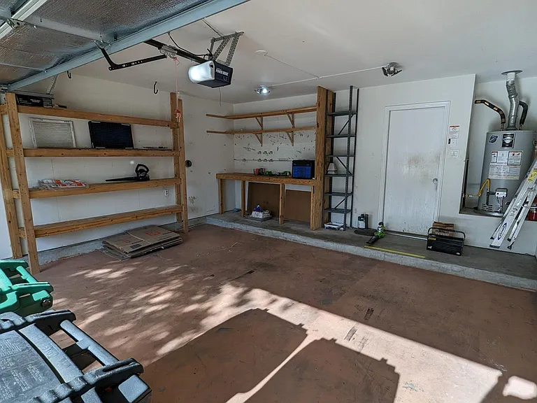 Garage with built-in workbench and wall storage. 40 gal gas water heater. insulated garage door.