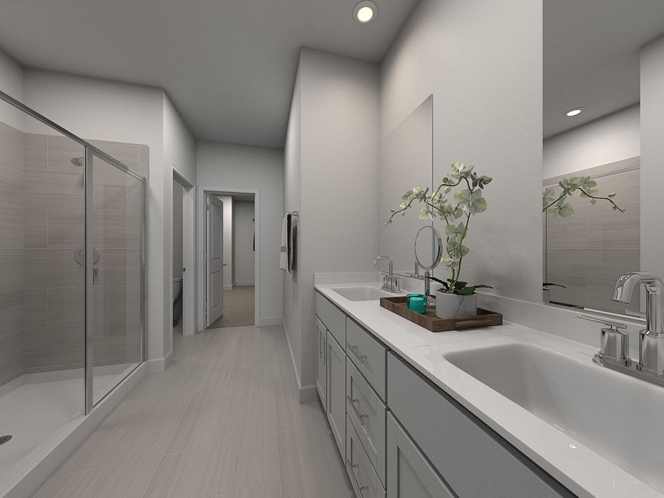 The primary bathroom offers dual vanity sinks and a walk-in shower.