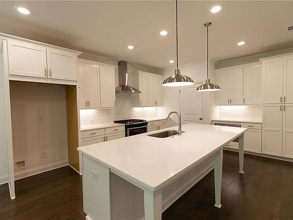 The Cool Linen Design Collection features white kitchen cabinets and quartz countertops.