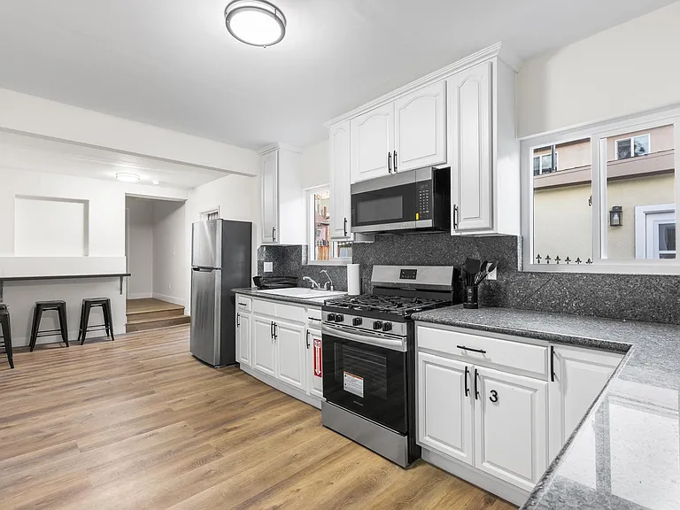 Updated kitchen with ample cabinetry, granite-look counters, gas range, and a convenient breakfast bar for seating.