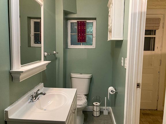 Bathroom with new toilet, vanity, sink and faucet with a glimpse of the inside of your front door.