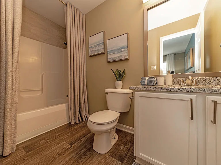 Bright bathroom with granite counters and bathtub