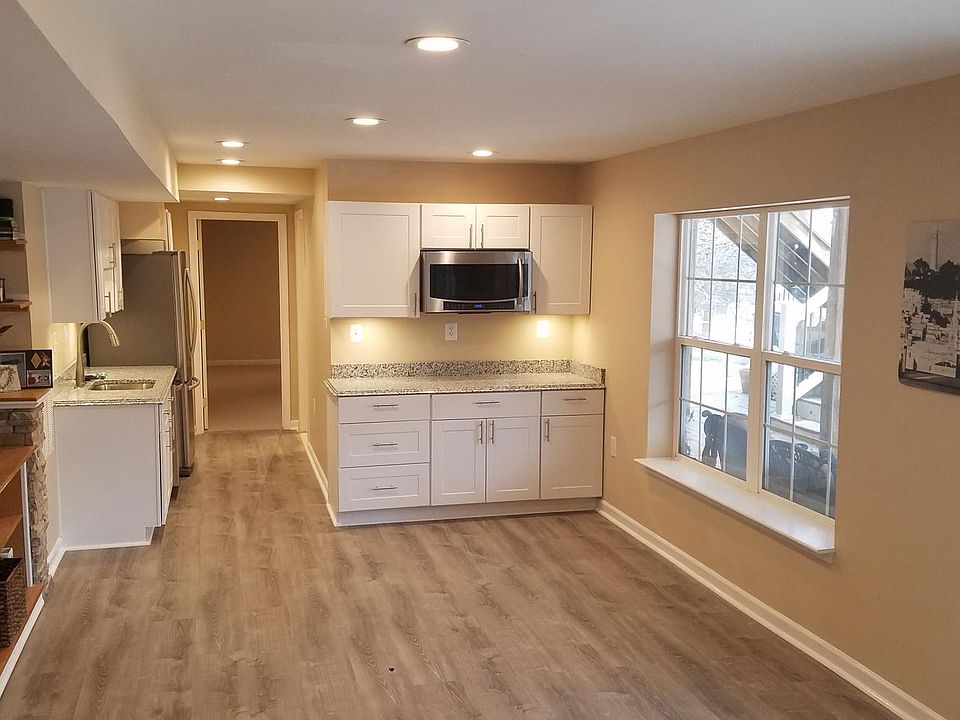The bright and airy kitchen is fully equipped, with views to the underdeck patio with lighting and ceiling fan to help bring the outdoors in!
