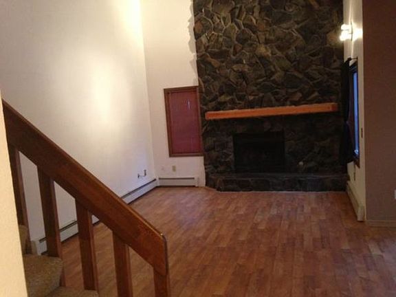 Living room with hardwood floors and beautiful rock fireplac