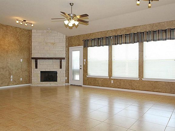Large family room with stone fireplace, tile, faux paint finishes, window treatments, and lots of na