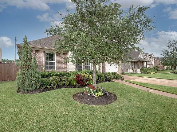 A view from the side of the home showing the lush landscaping and fabulous curb appeal.