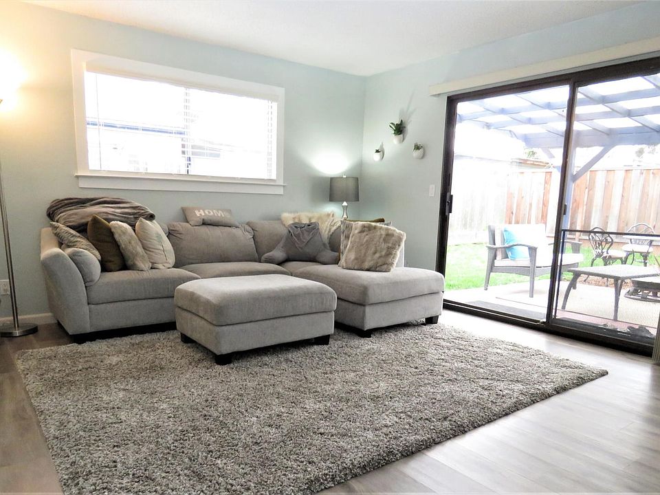 Living room with covered outside patio on right. Sliding glass doors to patio. Lots of light.