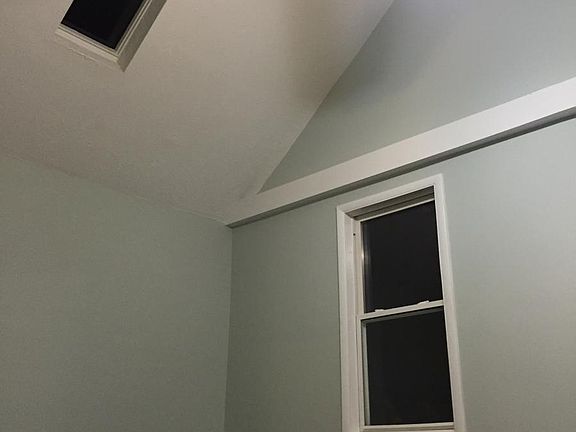 Large back bedroom with vaulted ceilings and skylight
