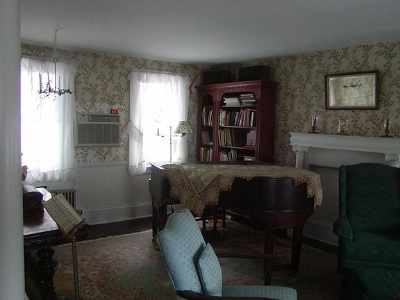 Spacious Family room with decorative fireplace and period wood floors
