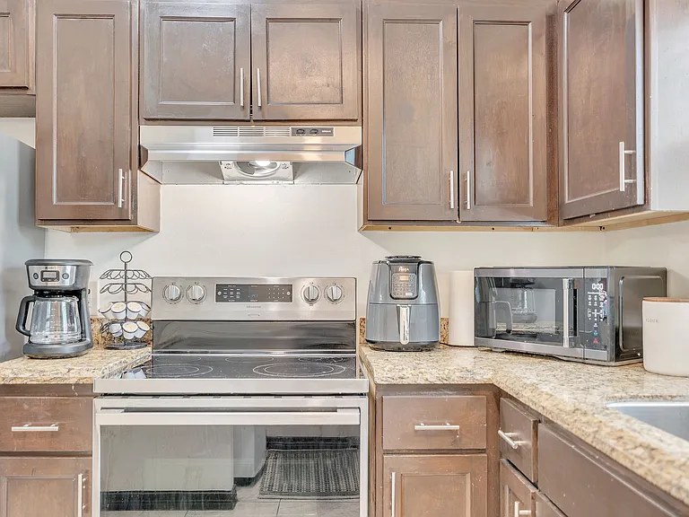 Modern kitchen featuring stainless steel appliances and granite countertops at La Joya Apartments in Laredo, Texas