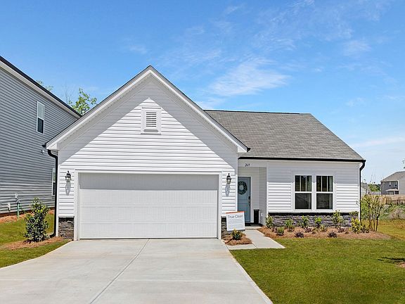 A white house with a garage and a driveway in front of it.