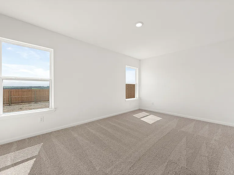 Spacious master bedroom with carpet.