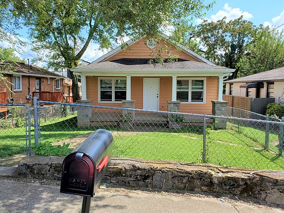 Fenced in front yard with street parking and a 1-car grassy parking spot.