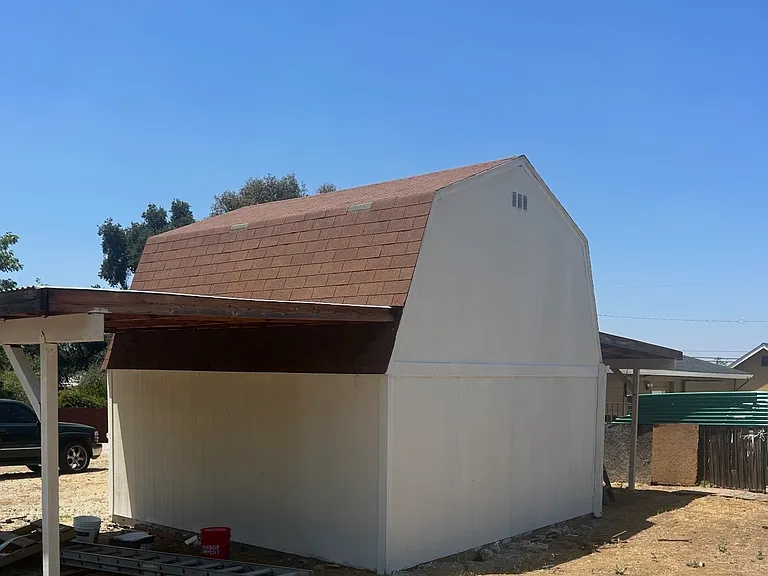 picture of small barn with two parking spaces in back yard