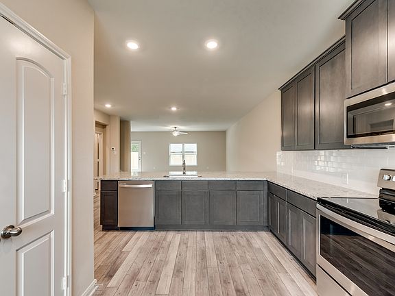 Enjoy stunning granite countertops and designer wood cabinetry in the kitchen.