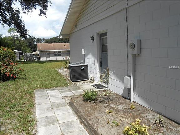 Side yard, entrance door to the garage and view to the back fenced yard.