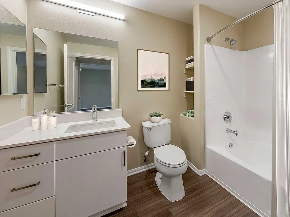 Renovated Package I bath with light grey quartz countertops, white cabinetry, and hard surface flooring