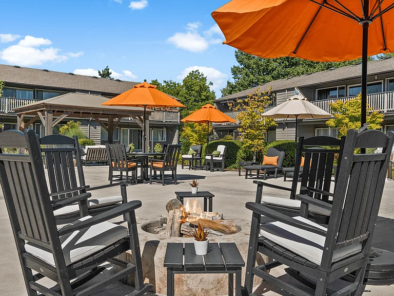 Cozy outdoor fire pit lounge with shaded seating for relaxation and gatherings.