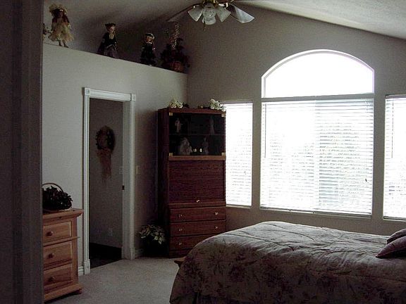 Master bedroom with nice plant shelf and vaulted ceiling and fan