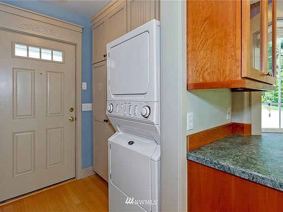 Back door entry has pantry and stackable washer and dryer and a "murphy" ironing board