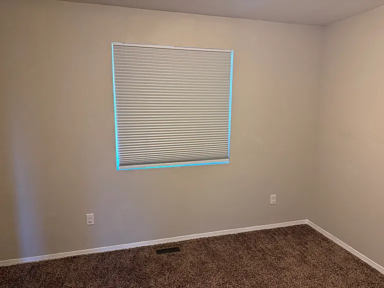 Secondary bedroom, featuring blinds and a closet.