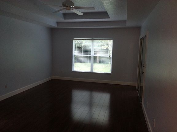 master bedroom with tiered ceiling, all hardwood floors