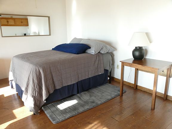 This is a large room with a brand new bed. It has an extra firm mattress but also an egg-crate mattress to cushion the bed. New linens. There are other furnishings not shown.