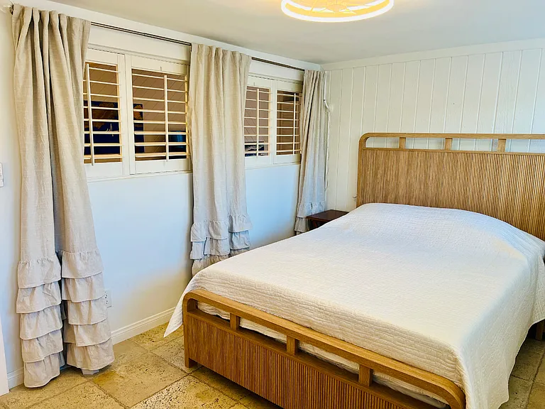 These shutters in the guest bedroom can be shut and the drapes close off the room