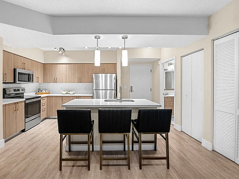 Modern kitchens include USB charging ports, islands, pendant lighting, wood-grain cabinets and stainless steel appliances