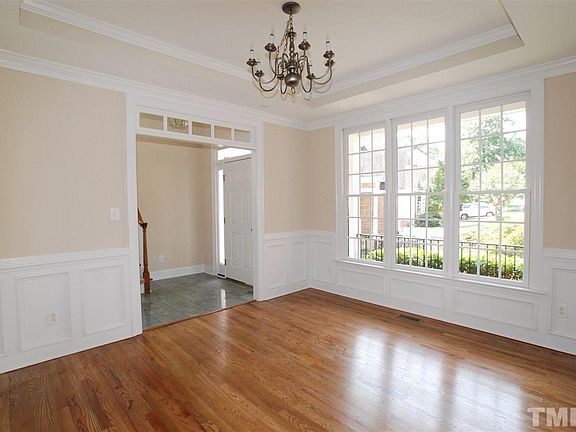 The Formal Dining features a Trey Ceiling with Crown Molding, Hardwood Flooring, Chair rail & Wainsc