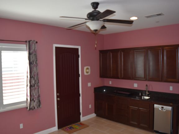 Kitchen view with main entry door closed, dishwasher and electric gas