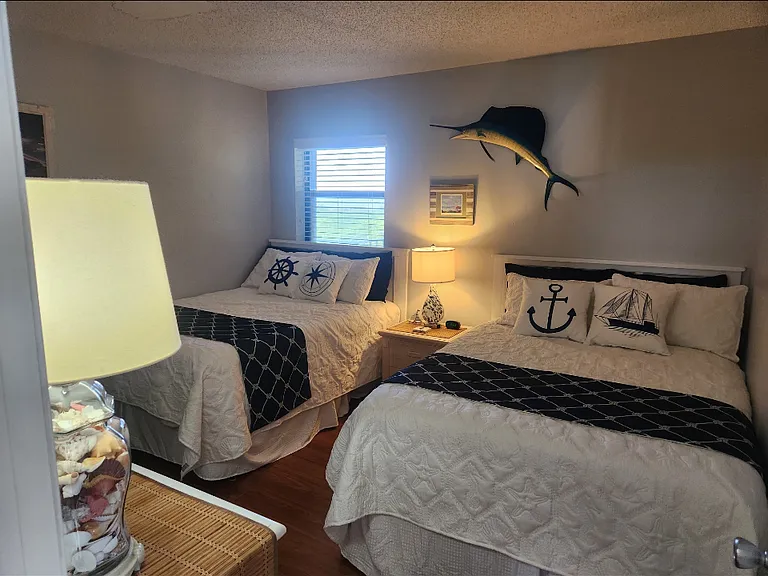 Guest bedroom with two new full size beds. Sitting on the bed you can see the ocean , I LOVE THAT !!