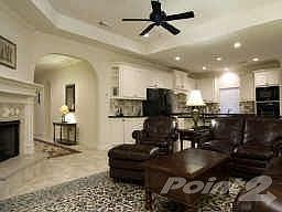 Another view of the family room with tile flooring, neutral colors and open to the kitchen.
