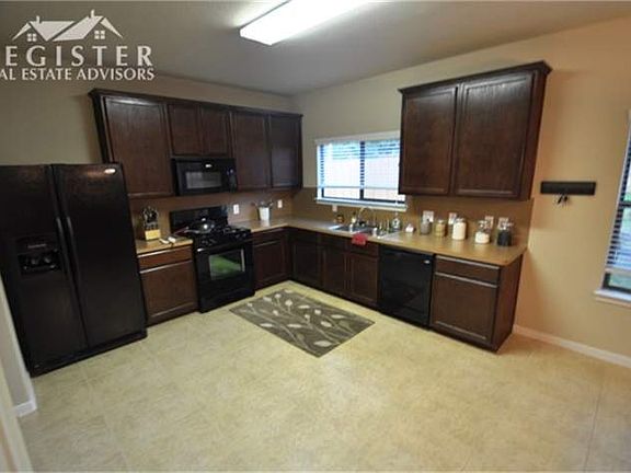 Open kitchen has 42 inch oak cabinets, stainless sinks, lots of natural light & tile.