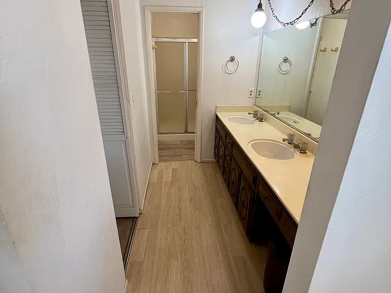 Primary bath vanity area with dual sinks, ample counter space, and an oversized mirror.