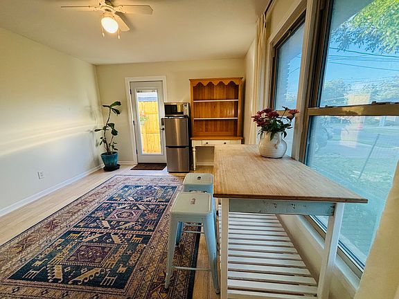Bright, open living space with bay windows overlooking a flower garden