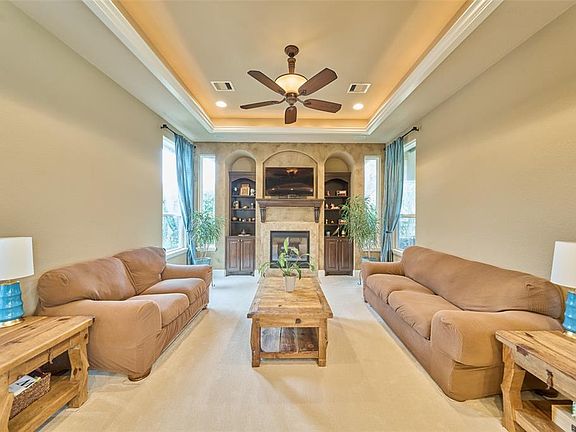 Image 3: Beautiful main living area with high ceilings, recessed lights, indirect lighting, and a fireplace. This area is right off the kitchen and great for entertaining.