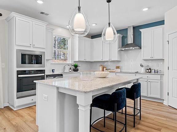 Bright modern Wynwood kitchen with pendant lighting, white cabinetry, and center island with seating