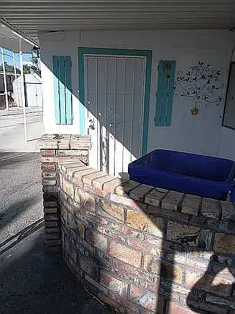 COVERED FRON PATIO WITH MEXICAN LADRIO PRIVACY WALL. FRONT DOOR WITH SECURITY SCREEN DOOR. COVERED PARKING