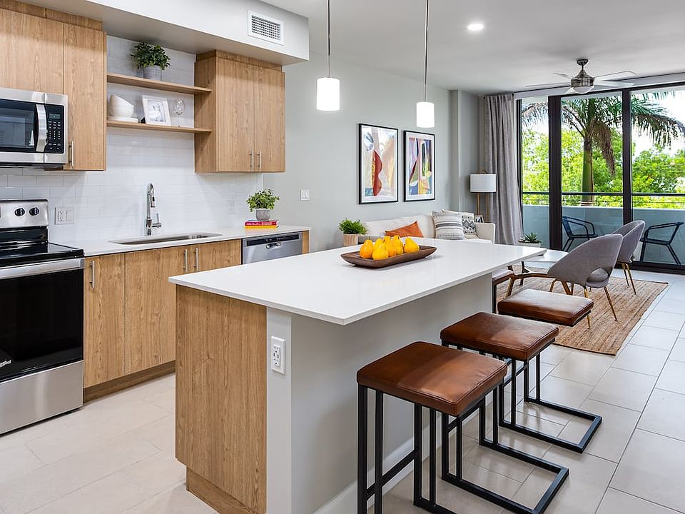 Open concept kitchen with quartz countertop, island, stainless steel appliances and tile backsplash