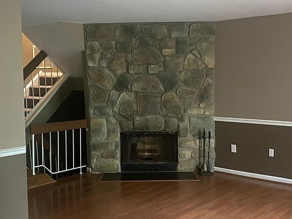 The heart of the living room is a stunning floor-to-ceiling stone fireplace, adding warmth, character, and a dramatic focal point to the space. Whether you're hosting guests or enjoying a quiet evening, this feature brings cozy elegance to your home.