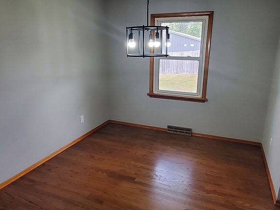 Dining room with hardwood floors and freshly painted walls.