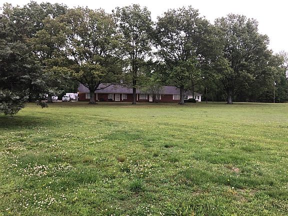 A distant view of the grounds on which the three cottages sit alongside a large home which serves as a quadplex.