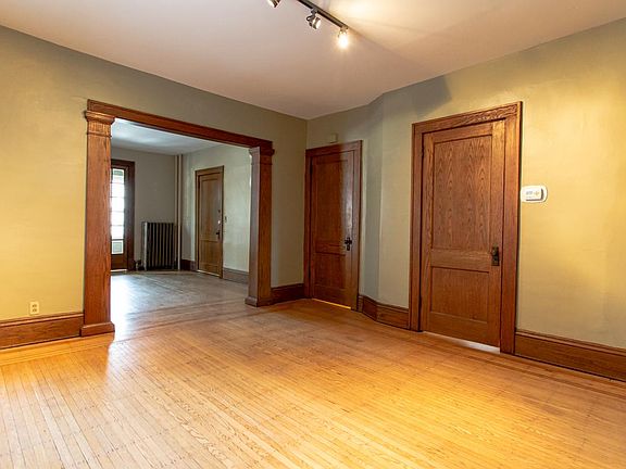 Dining room looking to living room - previous colors. New chandelier, neutral wall paint, blinds and freshly sanded floors in progress.