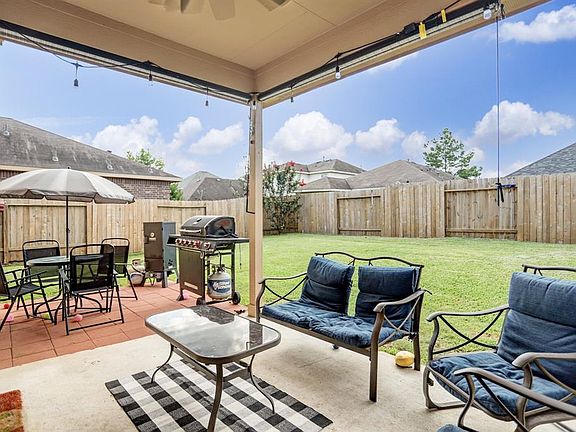 Watch a game under the covered patio, complete with ceiling fan and twinkle lights. Can you imagine the backyard barbecues here?!