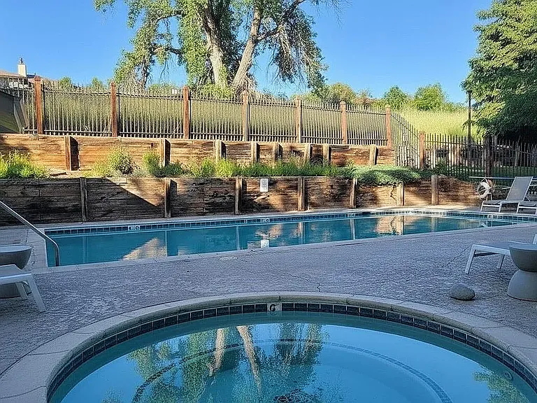 Outdoor swimming pool and hot tub for use during summer months.