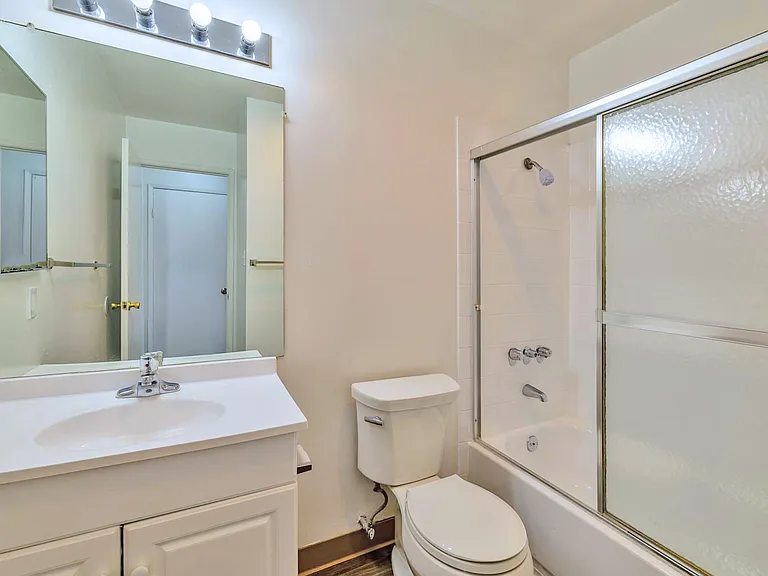 Bright, functional bathroom with full-sized shower and vanity.